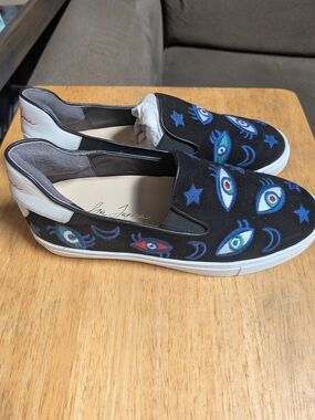 Black Slip-On Sneakers with Blue Embroidered Eye Motif